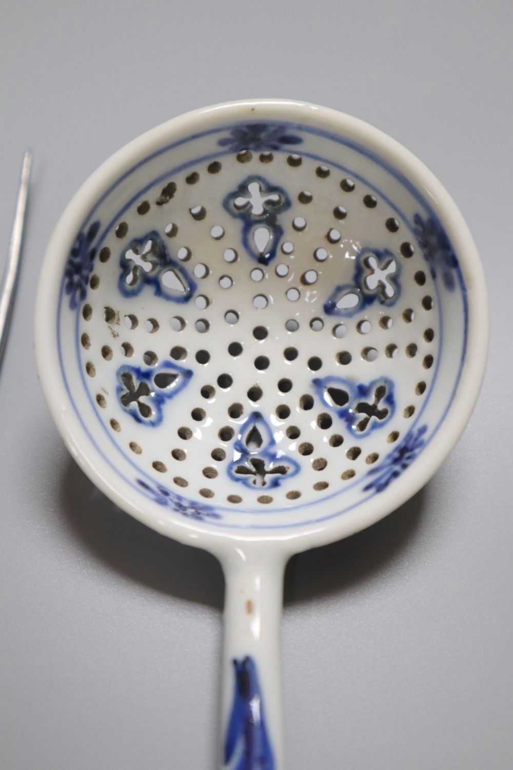 A Bow pistol grip blue and white handled fork, c.1770, 23cm, and a Continental porcelain blue and white strainer ladle, 17cm